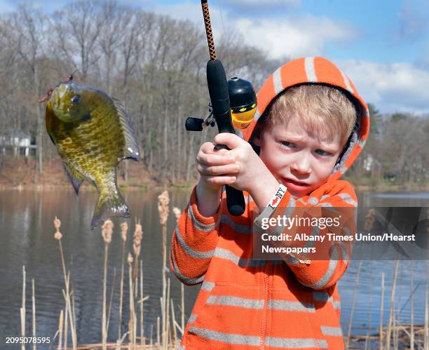 Six-year-old Liam Murphy of Clifton Park seems a little apprehensive as he lands a bluegill during the NYSDEC and Town of Clifton Park Open Space,...