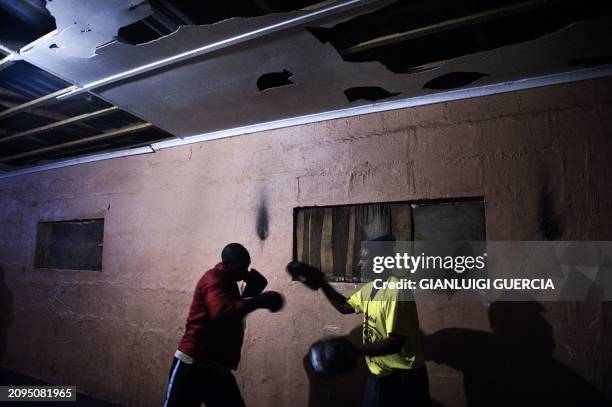 Young boxer trains with his coach in a dismissed apartheid era hostel turned gym in Kwanobuhle Township in Uitenhage on September 20, 2010 on the...