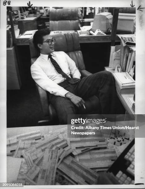 Hutton, Albany, New York office - Account Executive Rob Hom of Loudenville, numbed by today's experience, collapses into chair in front of pile of...