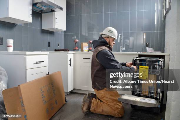 Jacob Luce of Collett Mechanical installs a dishwasher in a studio apartment at the @HudsonPark apartment complex under construction Tuesday Dec. 4,...