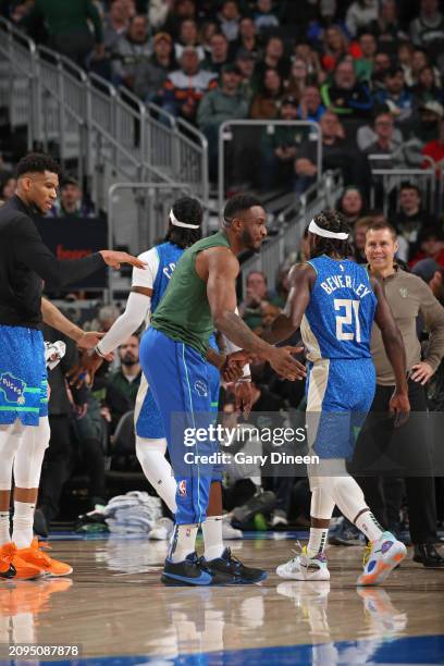 Thanasis Antetokounmpo and Giannis Antetokounmpo of the Milwaukee Bucks high five teammates during the game against the Brooklyn Nets on March 21,...