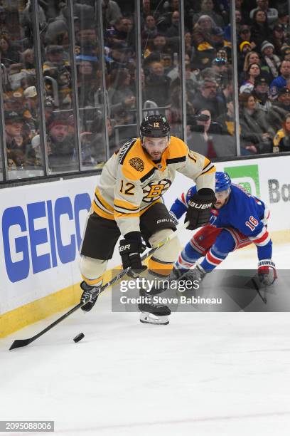 Kevin Shattenkirk of the Boston Bruins skates with the puck against Vincent Trocheck of the New York Rangers at the TD Garden on March 21, 2024 in...