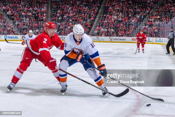 Simon Holmstrom of the New York Islanders controls the puck next to Olli Maatta of the Detroit Red Wings during the second period at Little Caesars...