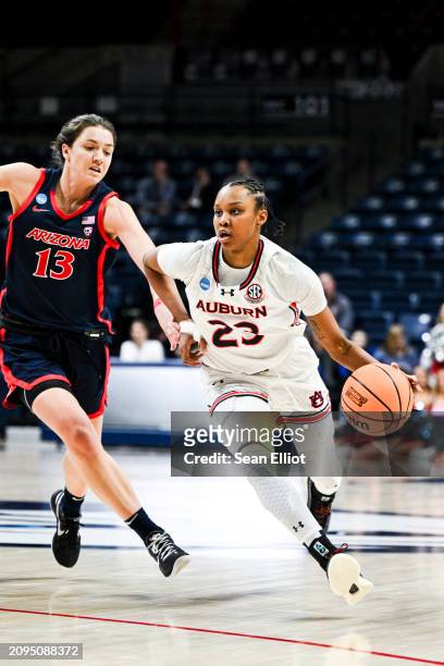 Honesty Scott-Grayson of the Auburn University Tigers drives past Helena Pueyo of the University of Arizona Wildcats during the First Four round of...