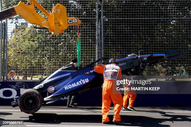 Marshals remove Williams' Thai driver Alexander Albon crashed car from the circuit during the first practice session of the Formula One Australian...