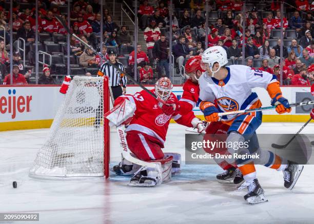 James Reimer of the Detroit Red Wings reacts to a shot as Shayne Gostisbehere defends against Pierre Engvall of the New York Islanders during the...