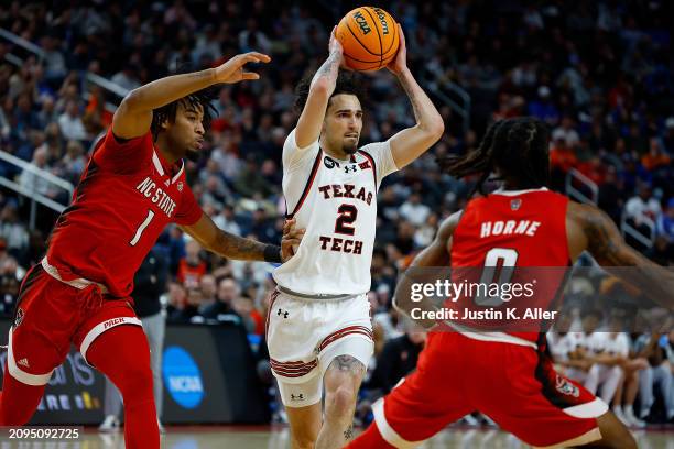 Pop Isaacs of the Texas Tech Red Raiders looks to make a play as he is defended by Jayden Taylor of the North Carolina State Wolfpack in the first...