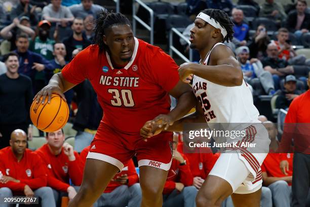 Burns Jr. #30 of the North Carolina State Wolfpack dribbles against Robert Jennings of the Texas Tech Red Raiders in the second half during the first...