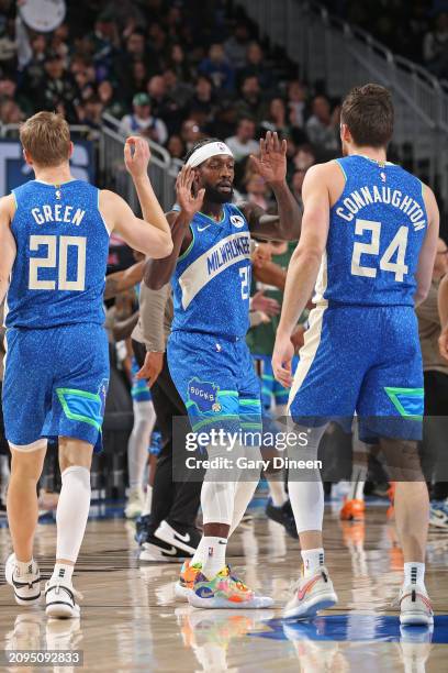 Patrick Beverley of the Milwaukee Bucks high fives Pat Connaughton and AJ Green during the game against the Brooklyn Nets on March 21, 2024 at the...