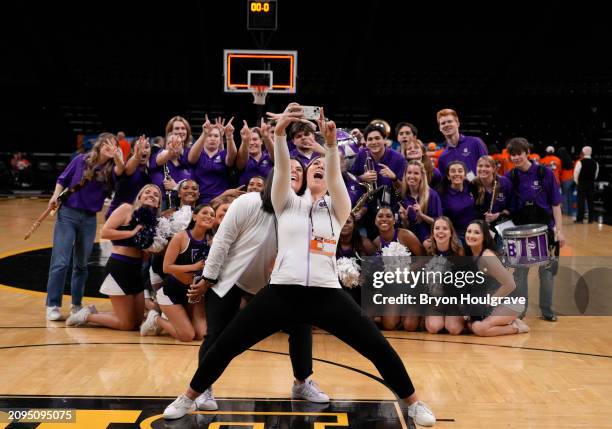 Members of the Holy Cross Crusaders pep band and cheerleading team pose for a selfie after the Crusaders women's basketball team beat the UT Martin...