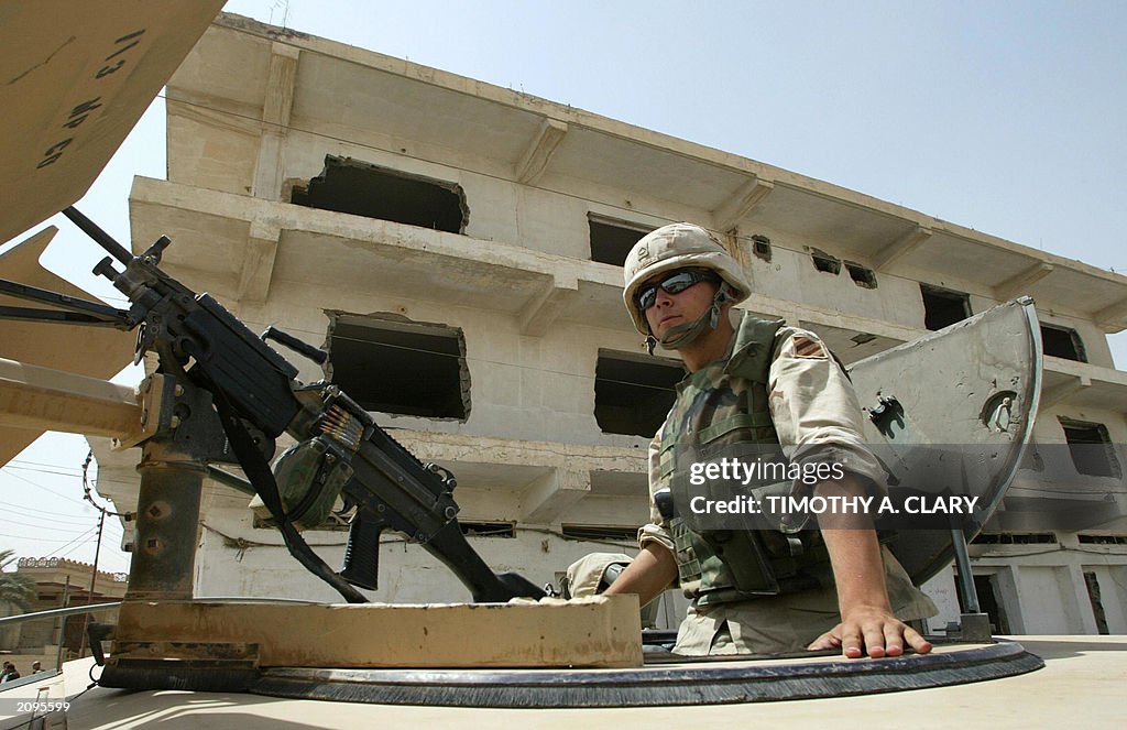 A US Army soldier sits on top of an armo