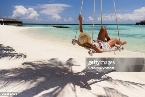 carefree woman relaxing in a swing on the beach. - meeru island stockfoto's en -beelden