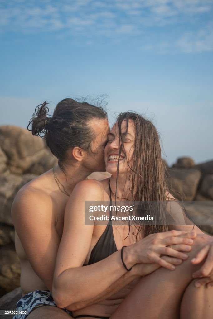 Giovane coppia abbraccio sulla costa rocciosa