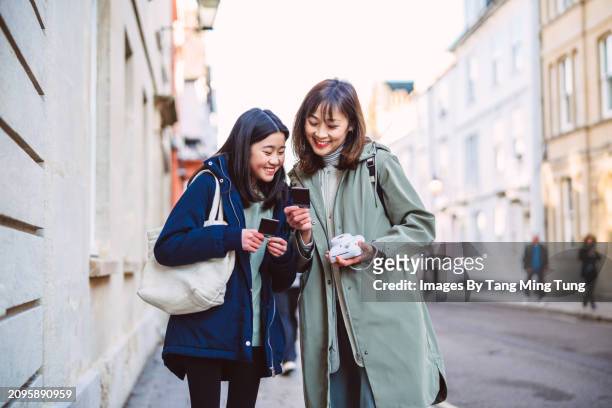 mom & her teenage daughter reviewing instant photos after taking pictures from instant camera while exploring in tourist district of an old town during vacation - photographic equipment stock pictures, royalty-free photos & images