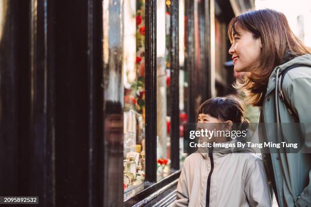 mom & daughter having window shopping outside a traditional antique shop while exploring in tourist district of a town - retail equipment stock pictures, royalty-free photos & images