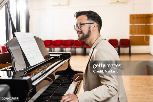 concert pianist plays piano in empty hall - pianist stockfoto's en -beelden