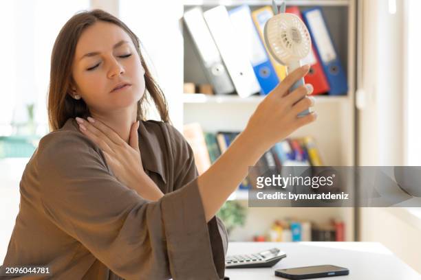 woman with fan giving her air and a fan in her hand - ac weary stock pictures, royalty-free photos & images