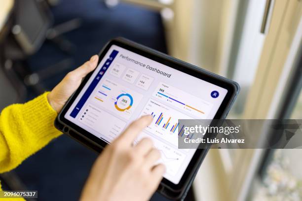 close-up of woman professional with infographic report on digital tablet in office - geschäftsstrategie stock-fotos und bilder