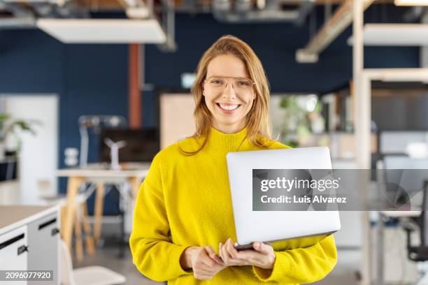 portrait of a successful young businesswoman standing in office - business woman stock-fotos und bilder