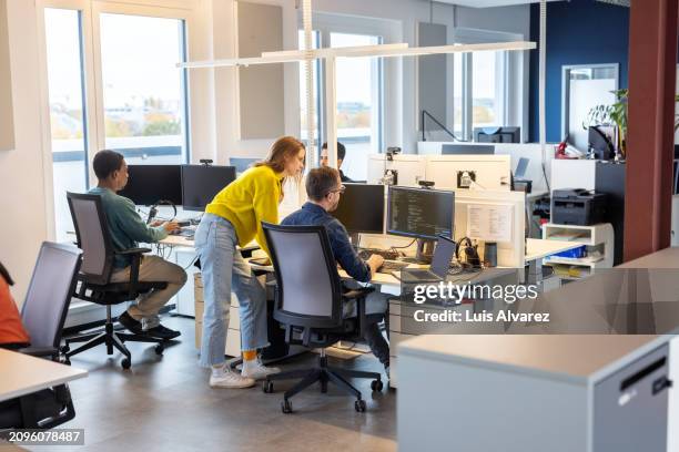 software programmers working in startup office - oficina de plan abierto fotografías e imágenes de stock