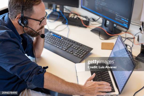 mature man customer support operator assisting a customer on call - suporte técnico imagens e fotografias de stock