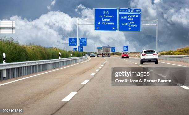 car's point of view, traffic of cars and trucks on a highway on a day with stormy skies. spain. - multiple lane highway stock pictures, royalty-free photos & images