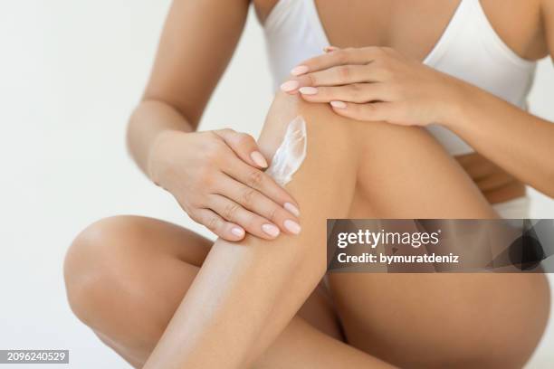 unrecognizable woman applying moisturizer - moisturizer stock pictures, royalty-free photos & images