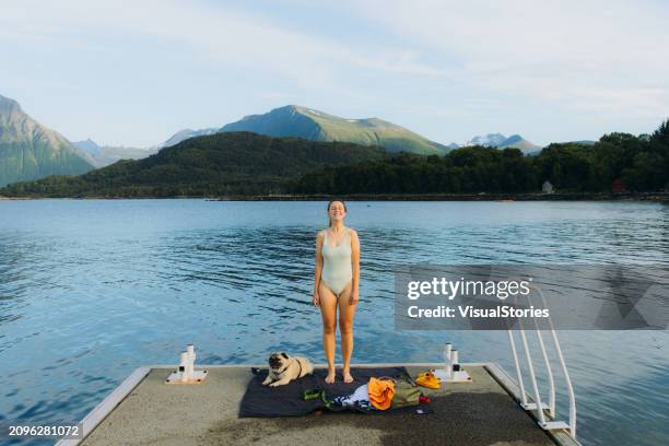 happy woman and dog admiring beach time by fjord in norway - hygge stockfoto's en -beelden