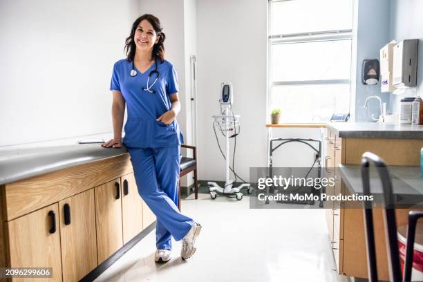 portrait of nurse smiling in exam room - doctor stethoscope patient whole body stock pictures, royalty-free photos & images