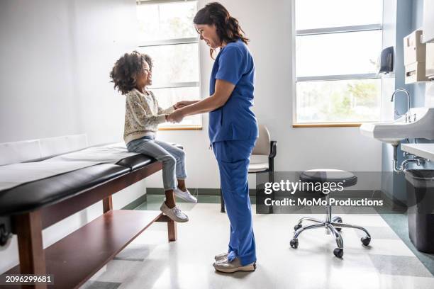 nurse and young girl talking in exam room - doctor stethoscope patient whole body stock pictures, royalty-free photos & images