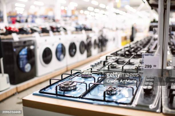 stoves  and washing machines for sale in a department store or showroom - elektromarkt stockfoto's en -beelden