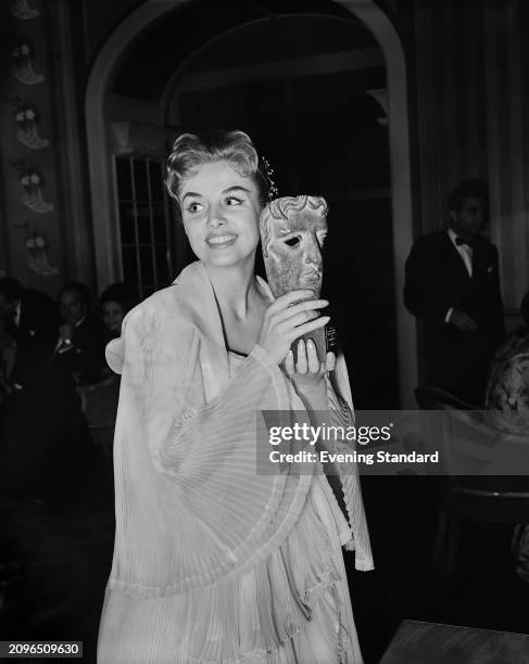 British singer Yana holding a Guild of Television Producers and Directors awards mask statuette, London, October 14th 1955.