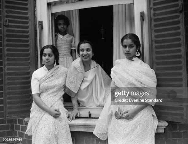 Diplomat and author Begum Shaistra Suhrawardy Ikramullah looking through an open window with her daughters from left, Salma Sobhan , Princess Sarvath...