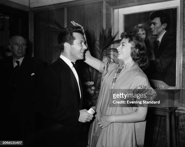 Actor and screenwriter Bryan Forbes with his fiancée, actress Nanette Newman at a film premiere in London, August 13th 1955. Behind them is a film...