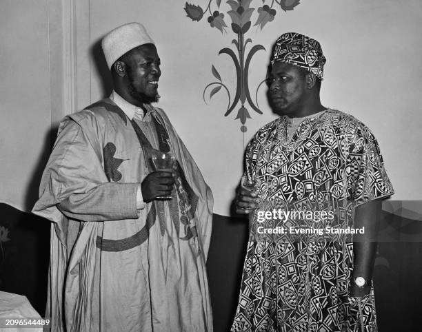 Minister of Works for Northern Nigeria, Ahmadu Bello, Sardauna of Sokoto , left, with Nigerian politician Festus Okotie-Eboh , during a social event,...