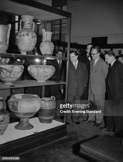 Deputy Soviet Premier Georgy Malenkov looks at a cabinet showing earthenware antiquities with a group of people at the British Museum, London, April...