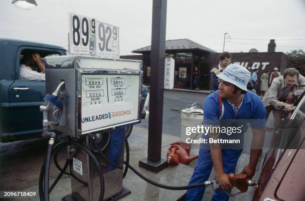 Attendant Joe Turchiano filling a car tank with gasohol at a petrol station off William Floyd Parkway in Shirley, Long Island, where the fuel mixture...
