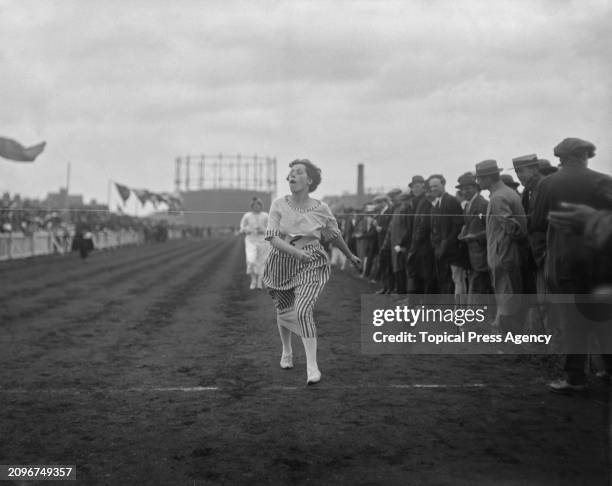 Female athlete named as A. McNaught winning the single women's walking race at the Interkit AA meeting at Manor Park, July 1920. Most women...
