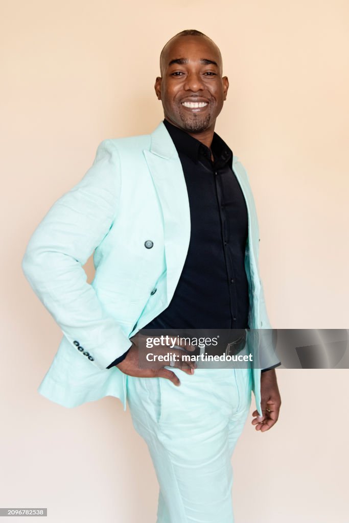 Portrait of stylish modern professional black man on beige background.