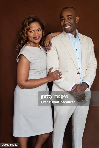 portrait of stylish modern professional black couple on brown background. - business mature couple portrait stock pictures, royalty-free photos & images