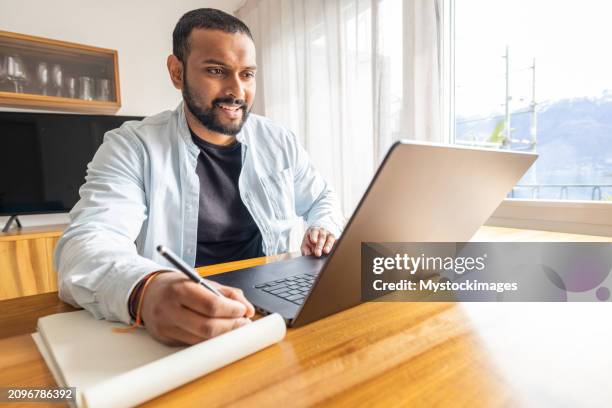 at-home productivity: young man focused on laptop workstation - sri lankan ethnicity stock pictures, royalty-free photos & images
