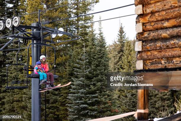 a mother and daughter riding on a charilift while skiing. - pulpit stock pictures, royalty-free photos & images
