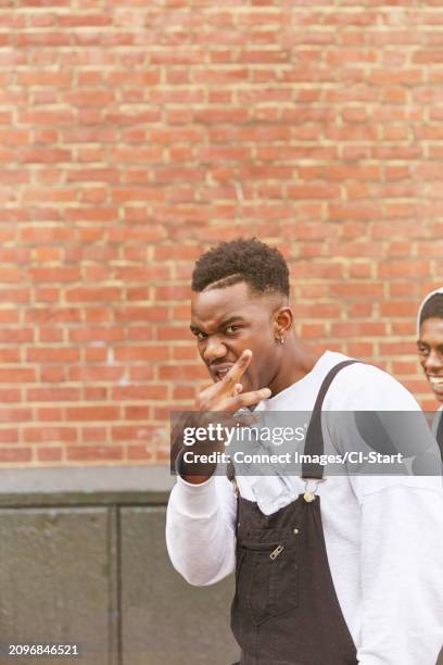 young man making gang sign - gang sign stock pictures, royalty-free photos & images