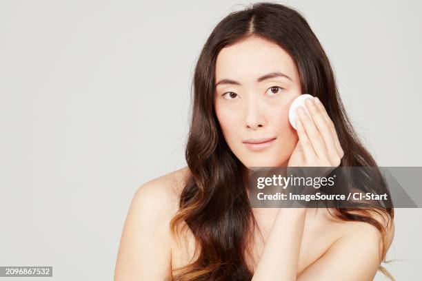 young woman wiping face with cotton pad - shoulder pad 個照片及圖片檔