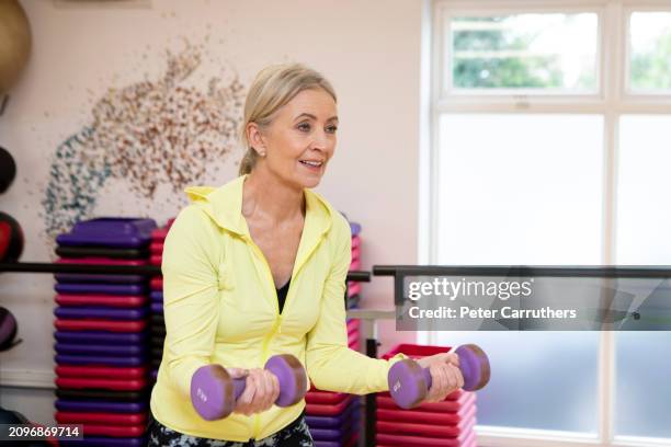 woman weight training in a gym - mature women exercise stock pictures, royalty-free photos & images