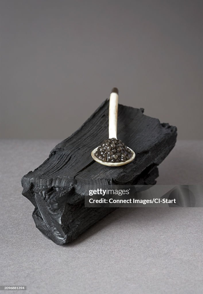 Spoonful of caviar on black log