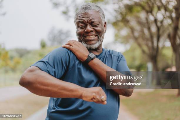 an elderly man with shoulder pain - shoulder stock pictures, royalty-free photos & images