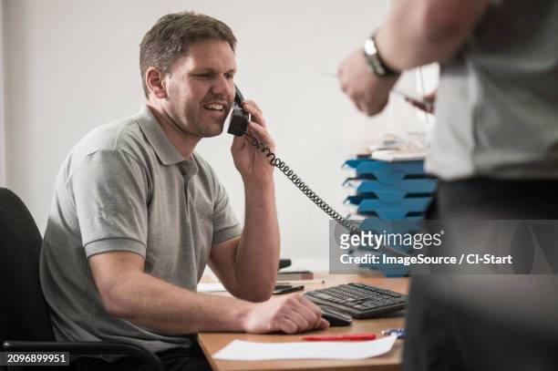 mechanic taking phone call - t shirt uniform stock pictures, royalty-free photos & images