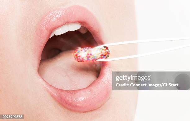 lips of woman taking glitter capsule with tweezers - tweezer stock pictures, royalty-free photos & images