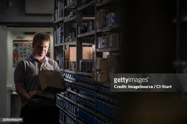 mechanic gathering parts from shelf - t shirt uniform stock pictures, royalty-free photos & images